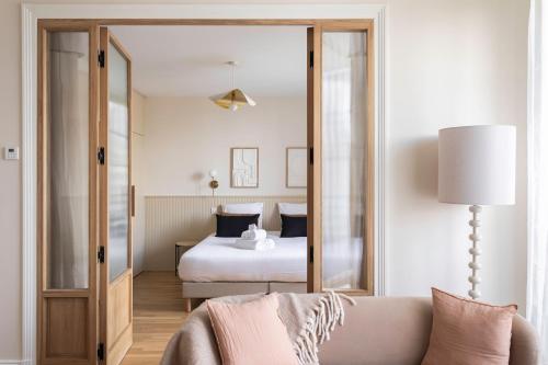 une chambre avec un lit et un grand miroir dans l'établissement L'Albatre - Proche plage de Dinard, à Dinard