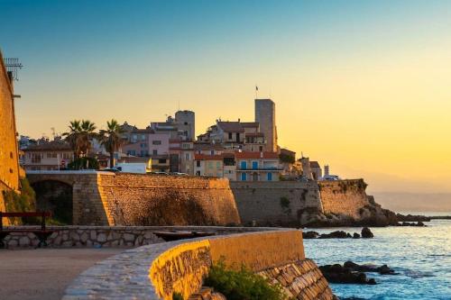 a group of buildings on a hill next to the ocean at Appartement de charme, 2P, Terrasse, Vue mer, Clim, Garage in Juan-les-Pins