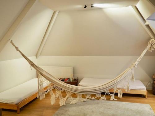 - une chambre mansardée avec un hamac dans l'établissement Villa Harpailles Golf forêt, à Le Touquet-Paris-Plage