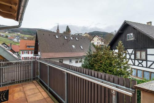 a balcony with a view of a town with houses at SCHUSTERjunge Aparthotel in Sasbachwalden