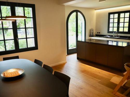 une cuisine et une salle à manger avec une table et des chaises dans l'établissement Villa Harpailles Golf forêt, à Le Touquet-Paris-Plage