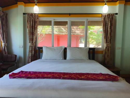 a bedroom with a large white bed with a window at Phi Phi View Point Resort in Phi Phi Don