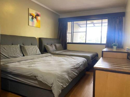 a bedroom with a bed and a couch and a window at Brinchang Cameron 2R2B 10 paxs KeaFarm #14402 in Brinchang