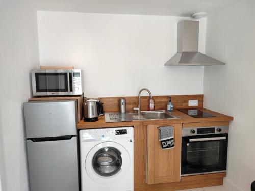 a kitchen with a sink and a microwave and a dishwasher at Golf Open Sport Houses in Saint-Fort