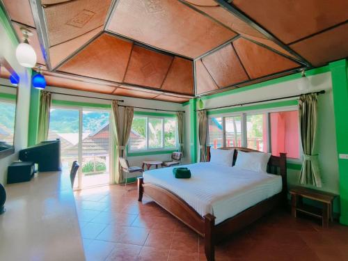 a bedroom with a bed in a room with windows at Phi Phi View Point Resort in Phi Phi Don