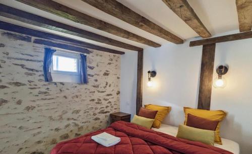 a bedroom with a red bed and a stone wall at Golf Open Sport Houses in Saint-Fort