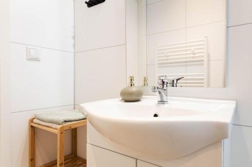 a white bathroom with a sink and a mirror at Luxe vakantiechalet met royale tuin op de Veluwe in Epe