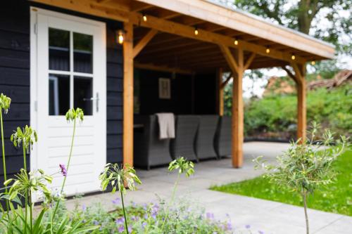 a screened in porch of a black house at Luxe vakantiechalet met royale tuin op de Veluwe in Epe