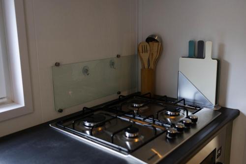 a stove top in a kitchen next to a counter at Luxe vakantiechalet met royale tuin op de Veluwe in Epe
