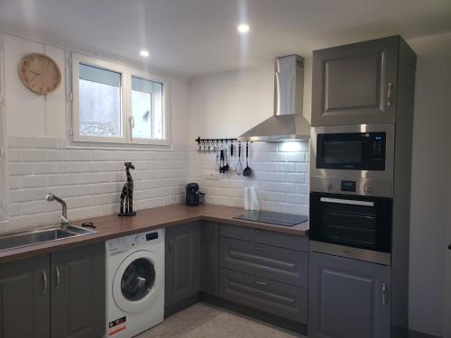 a kitchen with a washing machine and a washer at Maison Souquet in Lamalou-les-Bains