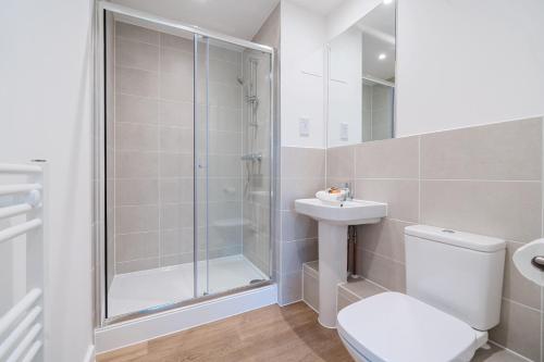 Un baño con ducha, inodoro y lavabo. en Roomspace Serviced Apartments - Walton Court, en Hersham