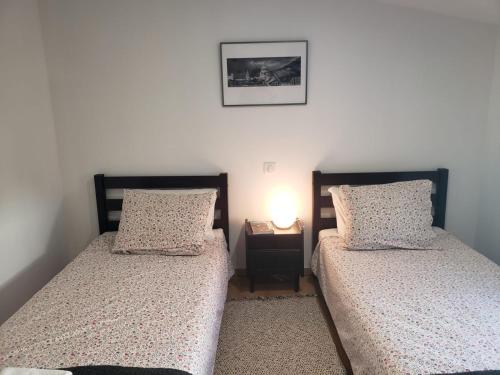 - 2 lits jumeaux dans une chambre avec une table de nuit dans l'établissement Maison Souquet, à Lamalou-les-Bains