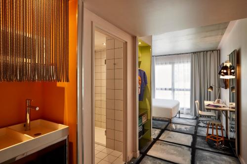 a bathroom with a sink and a shower and a room at Mama Shelter Lyon in Lyon