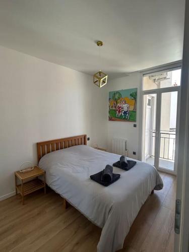 - une chambre dotée d'un grand lit avec deux chapeaux dans l'établissement Emplacement idéal SECURISE T2 Cosy Perpignan, à Perpignan