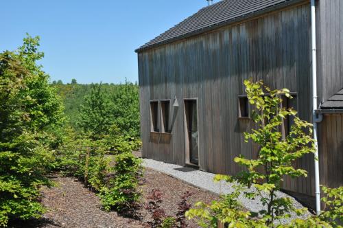 a wooden house with a garden in front of it at Jardins de L'Ourthe 8 in Houffalize