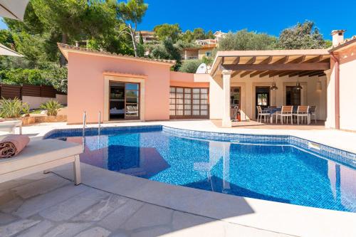 a swimming pool in a villa with a house at Beach Villa Margot by Sealand Villas in Port de Pollensa