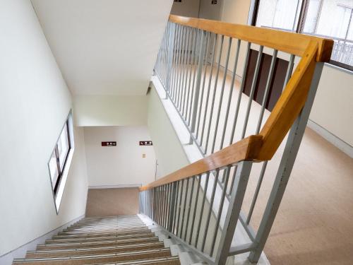 a staircase in a building with wooden railings at 手打ちそばの宿 石田屋 in Togari