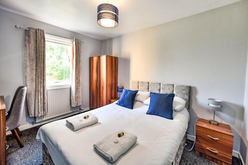 a bedroom with a large white bed with blue pillows at Hopetoun House in Springside