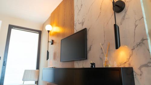 TV a/nebo společenská místnost v ubytování Mykonos Homes - Luxuriöses Penthouse mit Rooftop Pool, Meerblick, Gym