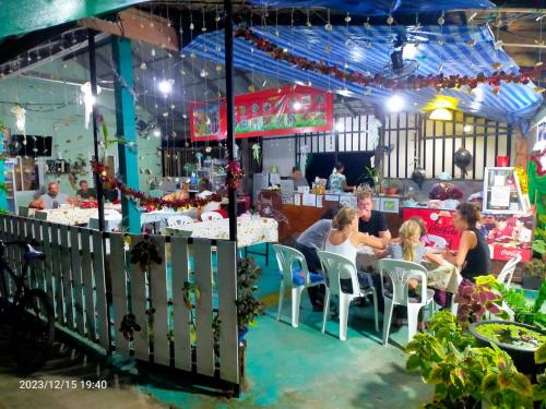 a group of people sitting at a table in a restaurant at Eco Bungalow in Ko Phayam