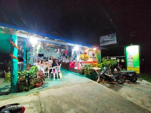 a restaurant with people sitting outside at night at Eco Bungalow in Ko Phayam
