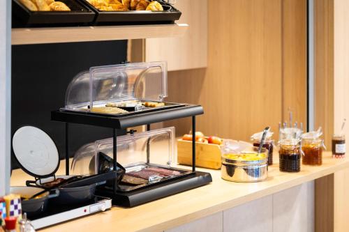 a buffet line with food on top of a counter at B&B HOTEL Liège Rocourt in Liège