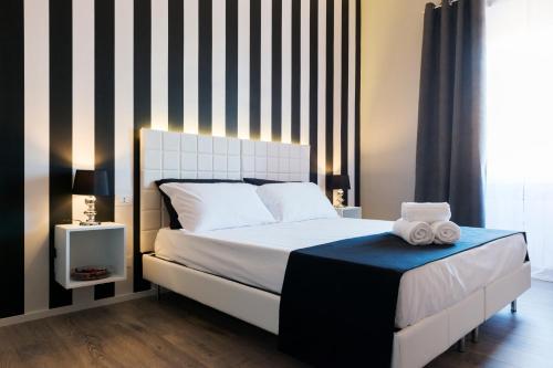 a bedroom with a bed with a black and white striped wall at Residenza Edoardo I in Rome