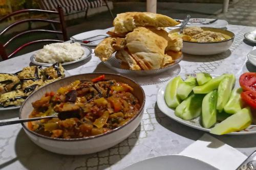 a table topped with bowls of food and vegetables at Hotel Vardzia K A L A in Aspindza