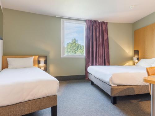 Ένα ή περισσότερα κρεβάτια σε δωμάτιο στο B&B HOTEL Clermont-Ferrand Nord Riom