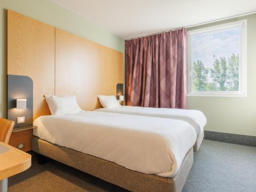 Ένα ή περισσότερα κρεβάτια σε δωμάτιο στο B&B HOTEL Clermont-Ferrand Nord Riom