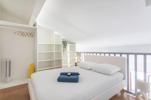 a bedroom with a white bed with a blue bag on it at Standing - Central - Quartier des Artistes - Les Frères de la Loc' in Marseille