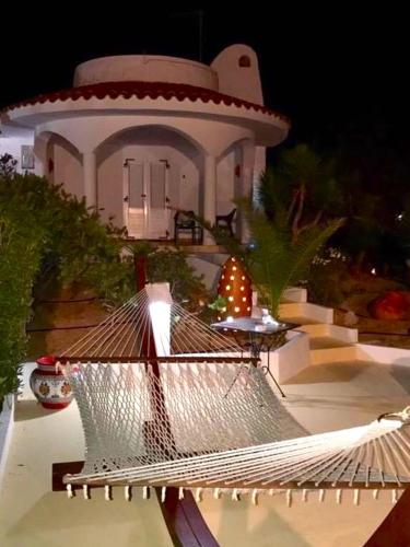 a building with a hammock in front of a house at Oasi Di Casablanca in Lampedusa