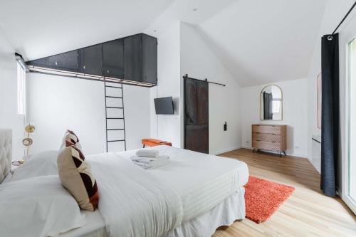 - une chambre blanche avec un grand lit blanc et un tapis rouge dans l'établissement Villa Romainville paris pour 8 personnes - FLAT-GUEST, à Romainville