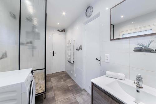 une salle de bain blanche avec un lavabo et un miroir dans l'établissement Villa Romainville paris pour 8 personnes - FLAT-GUEST, à Romainville