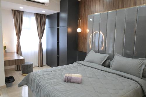 a bedroom with a large bed with a large headboard at Apartment Medan Podomoro City Deli by OLS Studio in Medan