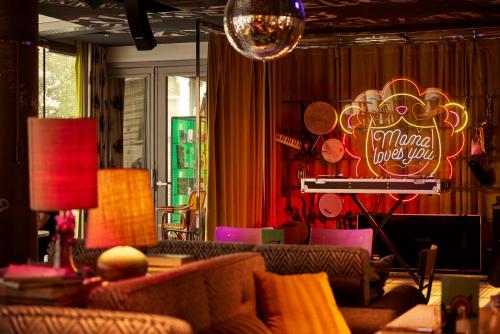 a living room with a couch and a piano and a sign at Mama Shelter Lyon in Lyon