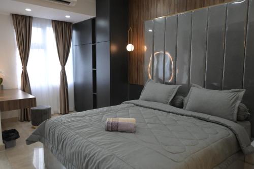 a bedroom with a large bed with a large headboard at Apartment Medan Podomoro City Deli by OLS Studio in Medan