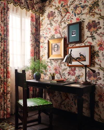 a desk with a lamp and a chair in a room with wallpaper at Graduate by Hilton Palo Alto in Palo Alto