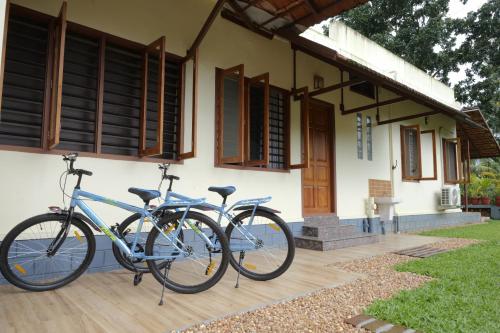 two bikes parked in front of a house at Neelambari - Riverside Private Bedroom in Kumarakom