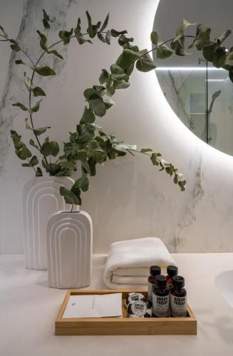 a bathroom with a wooden tray with five jam jars at Sentro Boutique Hotel in Sofia