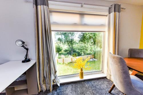 a room with a window with a desk and a table and a table and chairs at Hopetoun House in Springside