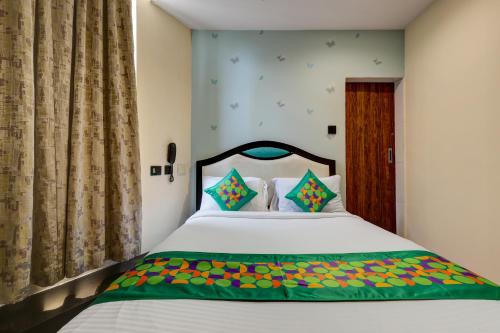 a bedroom with a large white bed with colorful sheets at Treebo Blak & Wite Rk Beach in Visakhapatnam