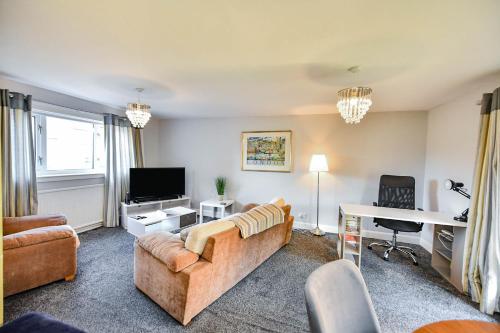 a living room with a couch and a tv and a desk at Hopetoun House in Springside