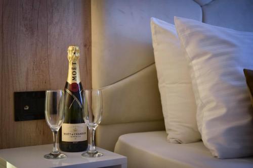 a bottle of champagne and two wine glasses on a table at Hotel Sumadija in Belgrade