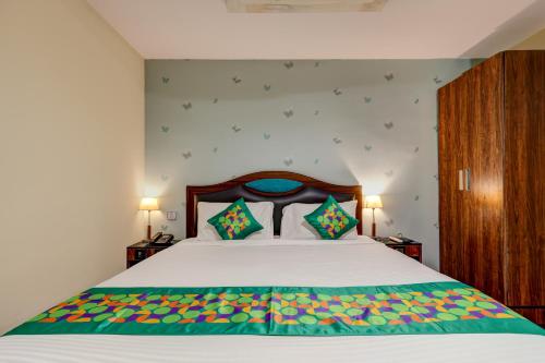 a bedroom with a large bed and two lamps at Treebo Blak & Wite Rk Beach in Visakhapatnam