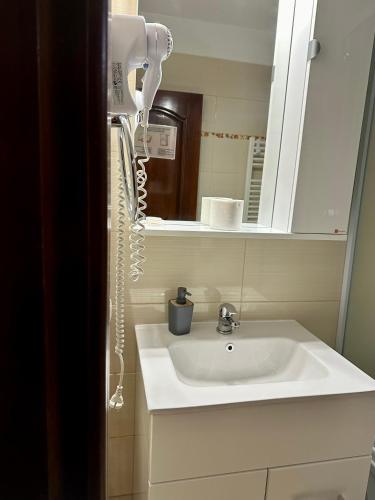 a bathroom with a white sink and a mirror at Pensiunea Aristocrat in Iaşi