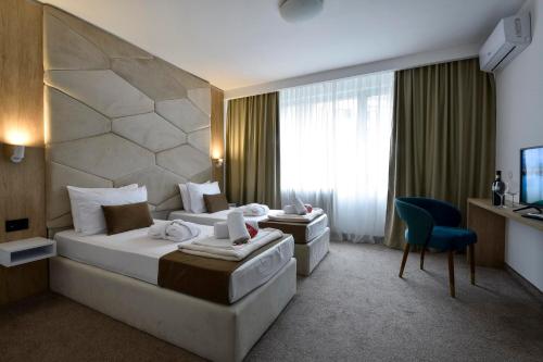 a hotel room with two beds and a television at Hotel Sumadija in Belgrade