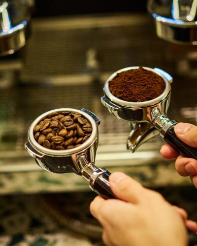 a person is holding a cup filled with coffee at B Hotel Kuala Lumpur in Kuala Lumpur