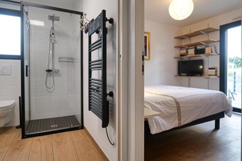 Cette chambre comprend un lit et une salle de bains pourvue d'une douche. dans l'établissement Jolie maison récente avec jardin et piscine Les Sables - 8 personnes, à Les Sables-dʼOlonne