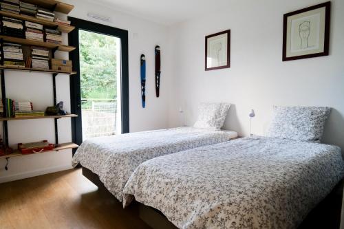 une chambre avec deux lits et une fenêtre dans l'établissement Jolie maison récente avec jardin et piscine Les Sables - 8 personnes, à Les Sables-dʼOlonne